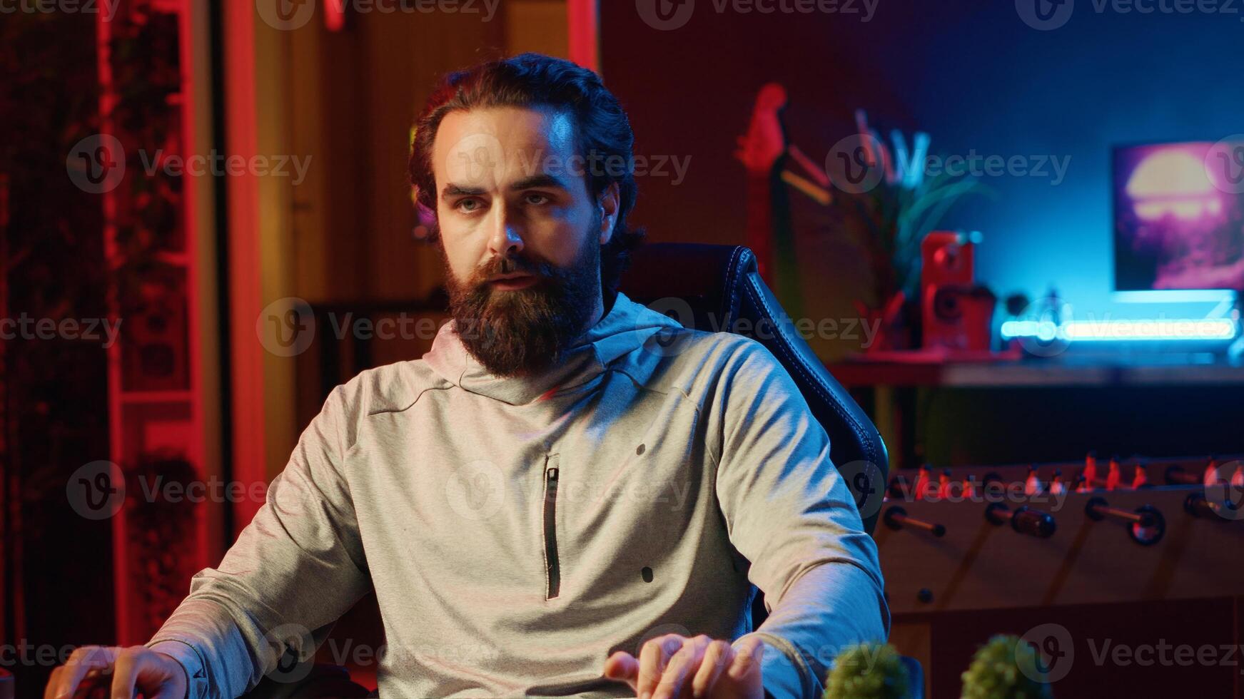 Stressed man playing videogames at home, struggling to keep up with over leveled opponents, spamming keyboard buttons. Tense player participating in esports tournament, struggling to defeat enemies photo