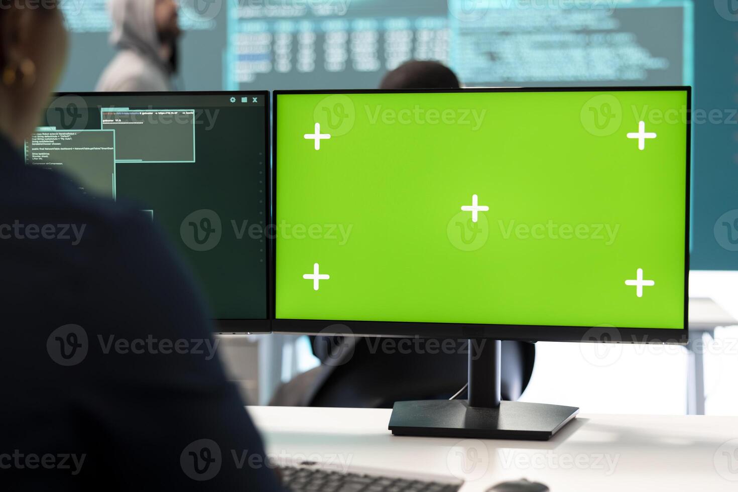 Governmental hackers using green screen in performing cyber security monitoring and threat detection. Examining network security and protection against cyber attacks, national intelligence. photo