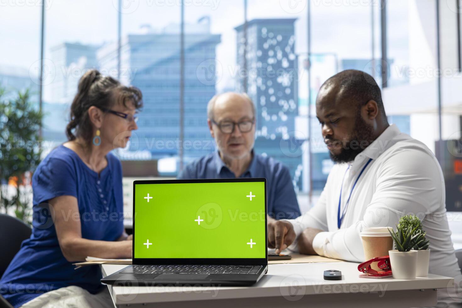 Senior people discussing with broker about securing a pension option, having a copy space mockup on laptop in office. Old clients choosing a retirement plan for life insurance. photo