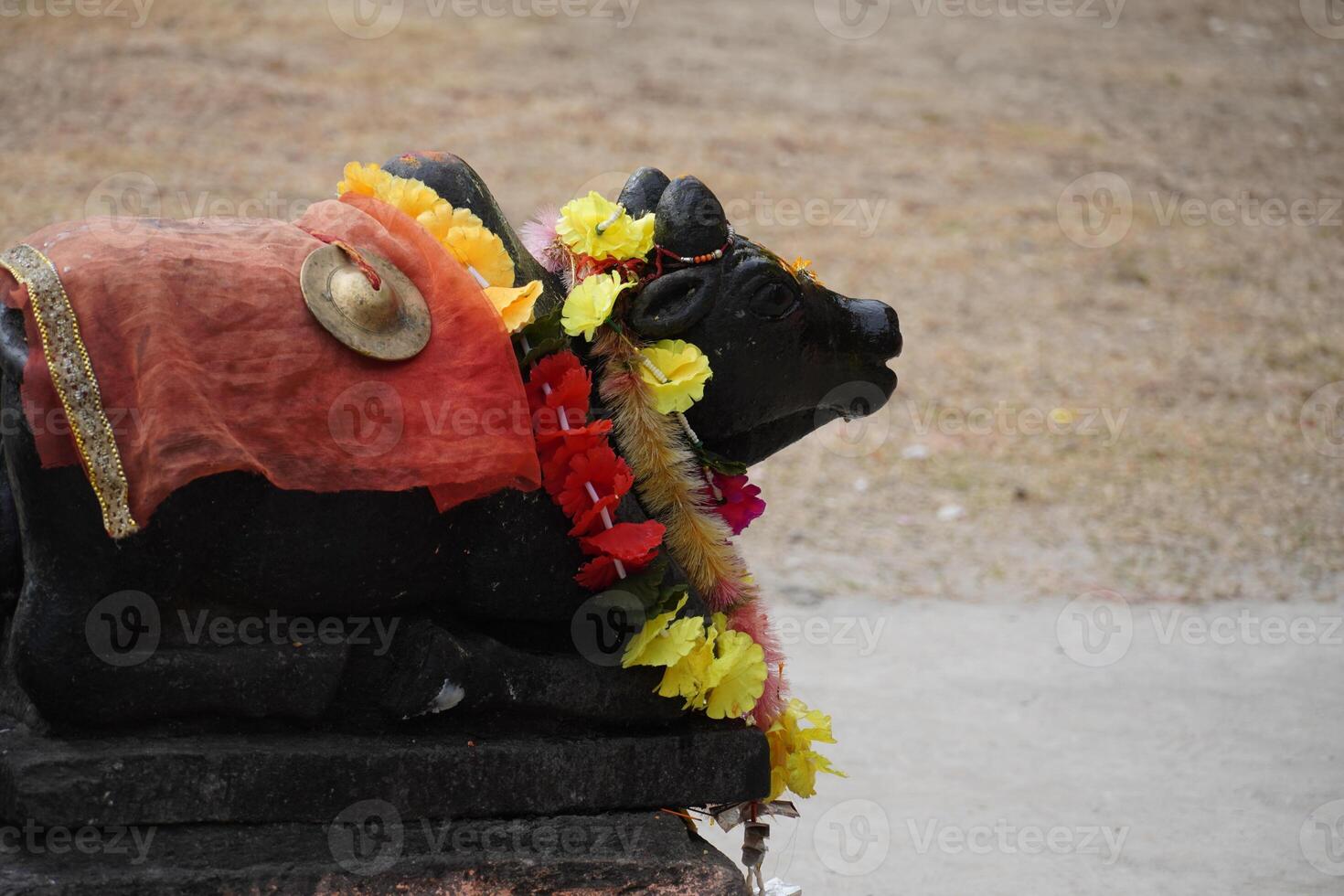 A statue of a cow with a red cloth on it photo