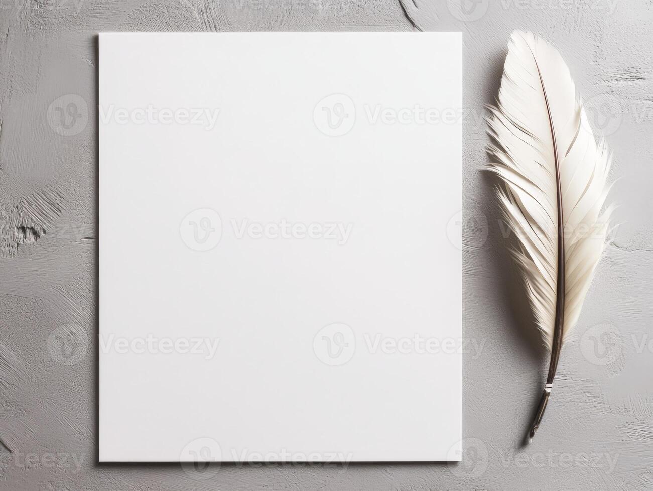 A blank sheet of paper beside a white feather on a textured surface. photo