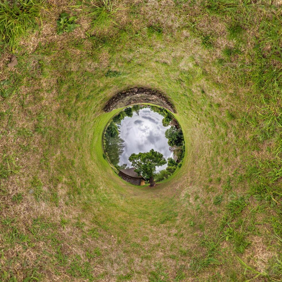 A circular hole in the ground with grass and trees photo
