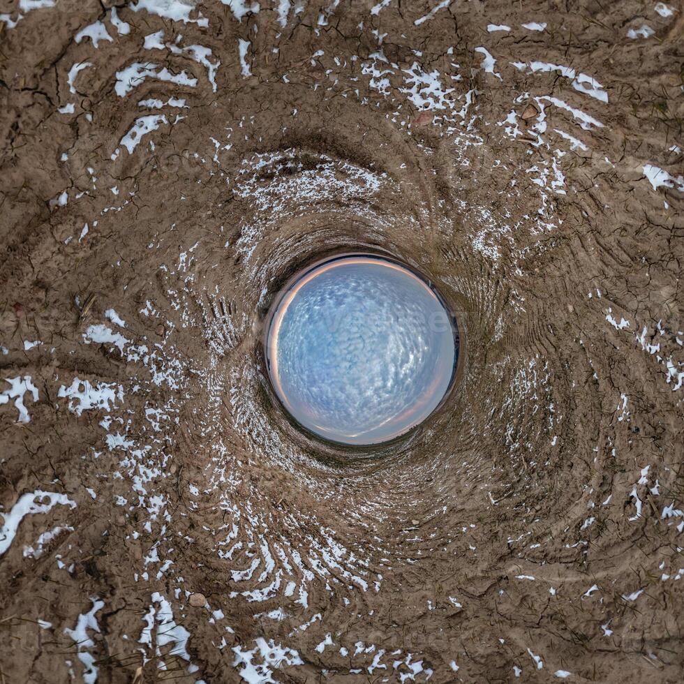 A circular hole in the ground with a blue sky photo