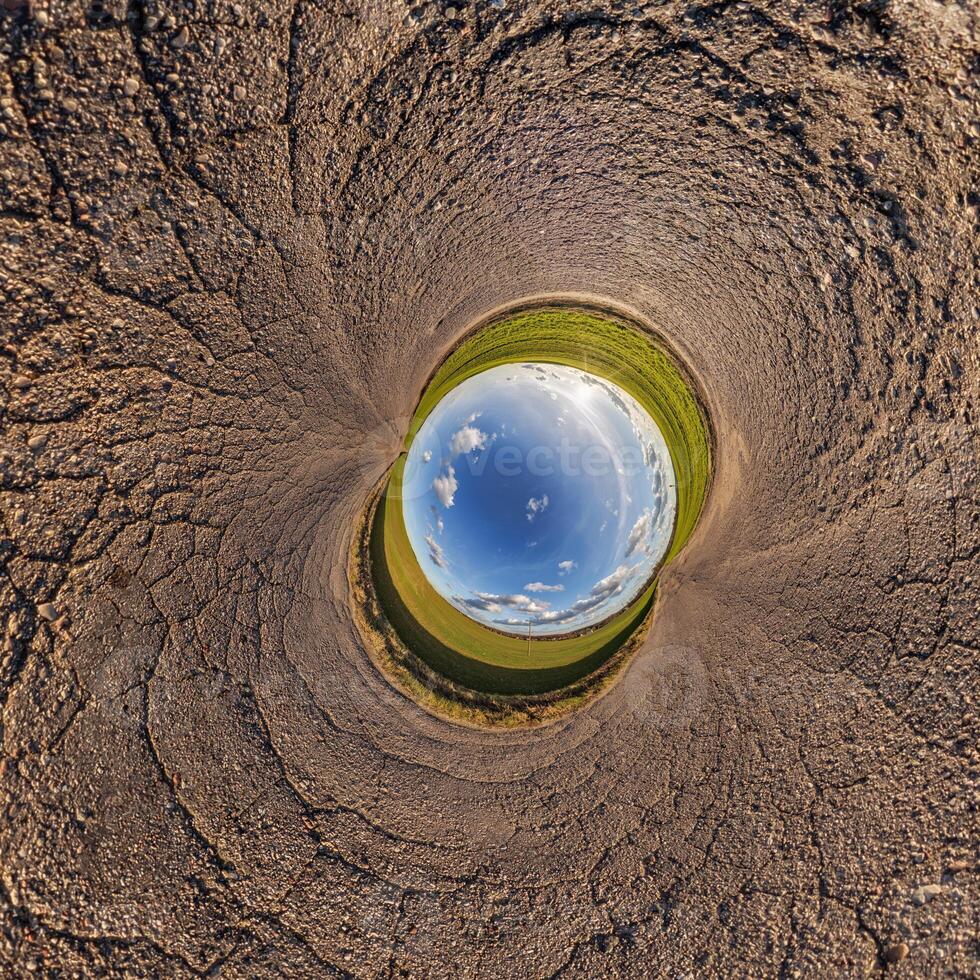 A circular hole in the ground with a blue sky photo