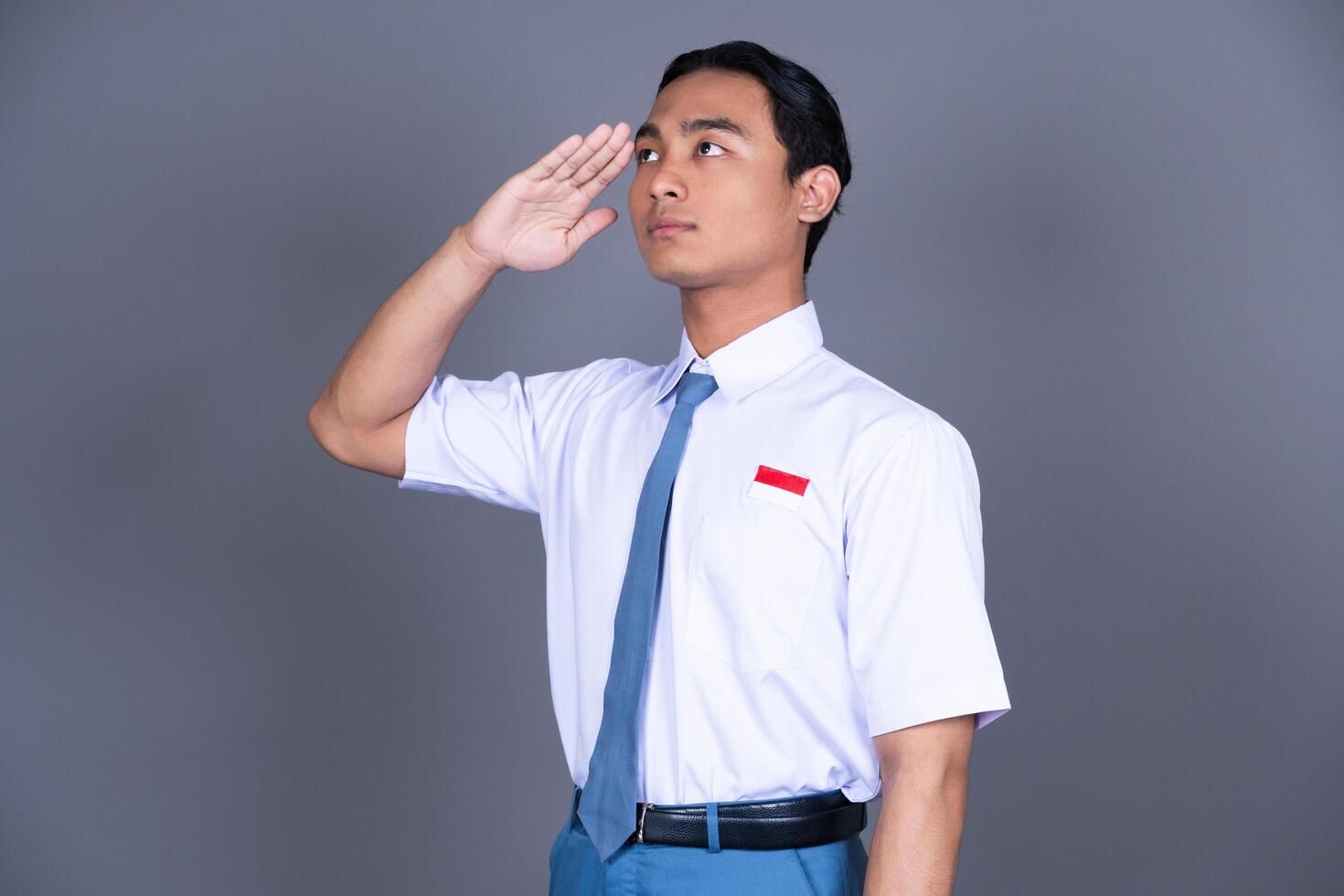 Indonesian Male High School Student in Uniform Hand Salute Gesture photo