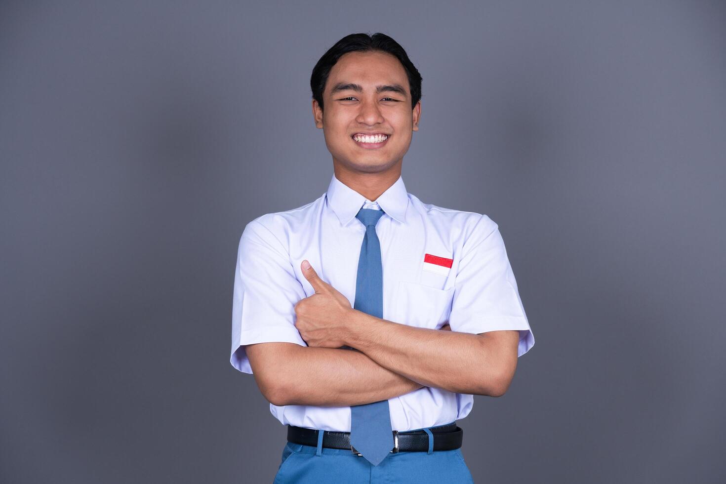 Indonesian Male High School Student in Uniform Giving a Crossing Thumbs Up photo