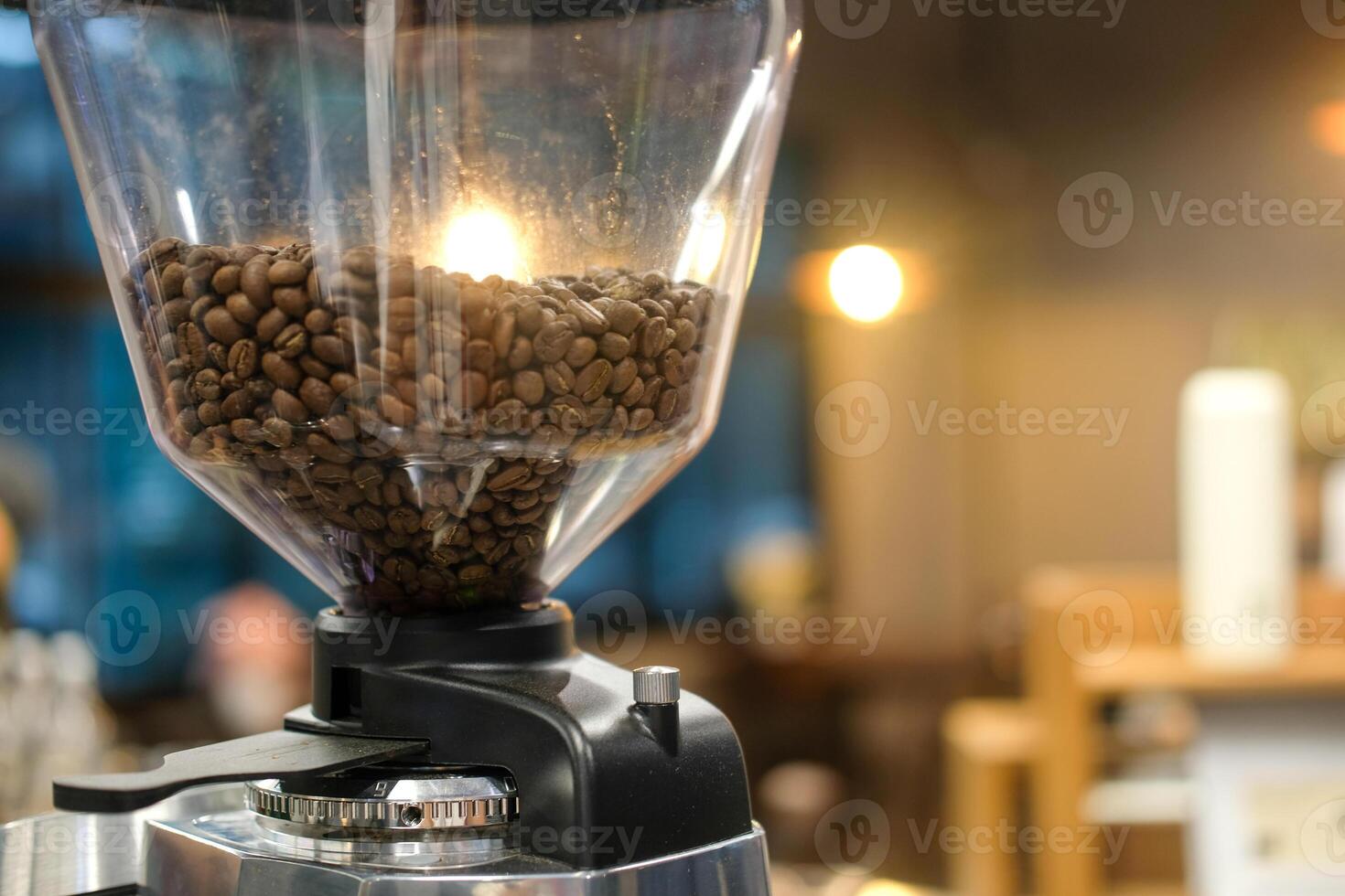 Coffee beans inside the machine hopper in cafe. photo