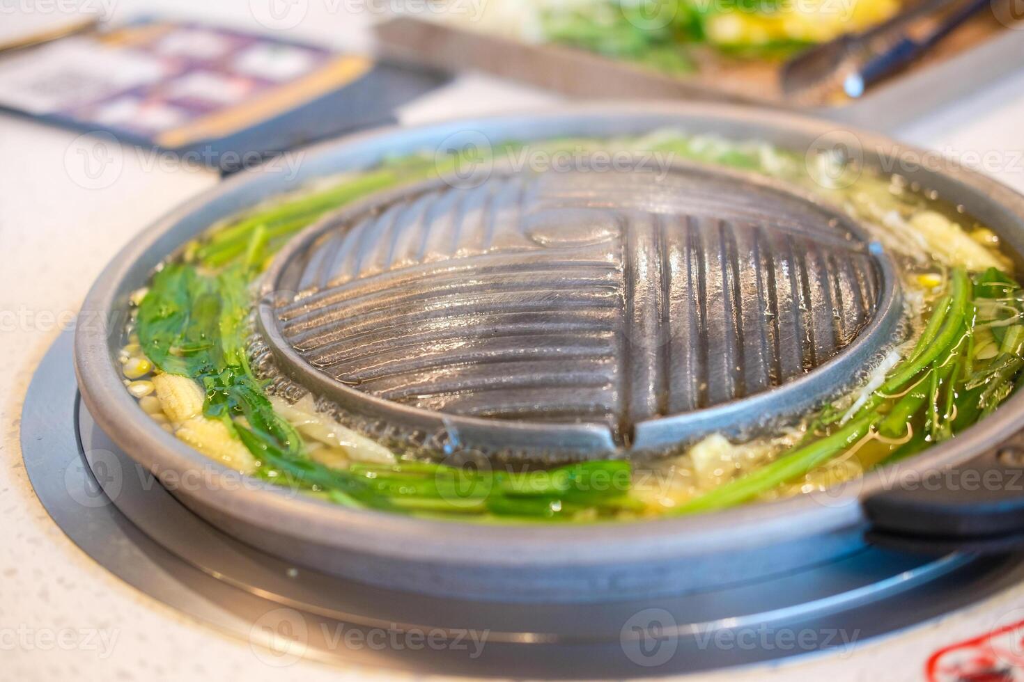 Barbecue hot pan prepare cooking Moo Kra Ta with boiled vegetable in hot pot. photo