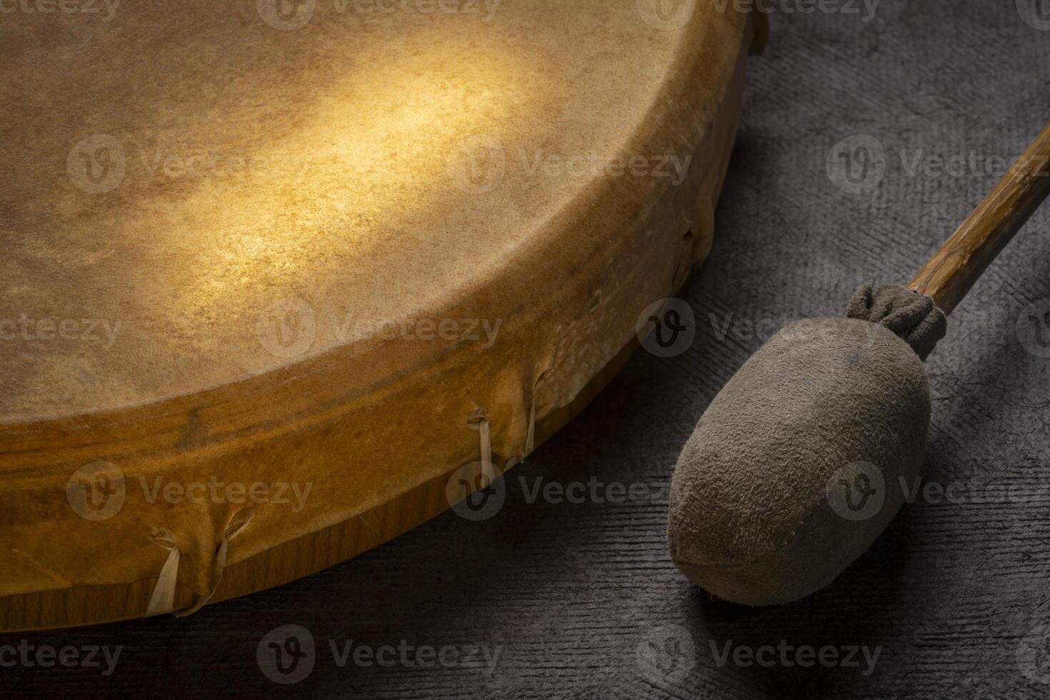 native American style, shaman frame drum covered by goat skin with a beater photo