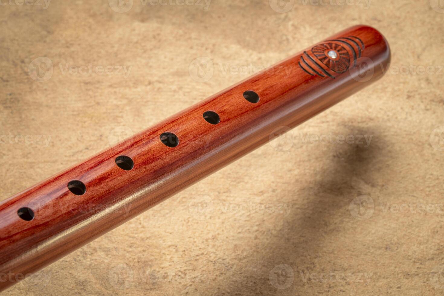 native American style flute handcrafted from cedar wood against textured art paper photo