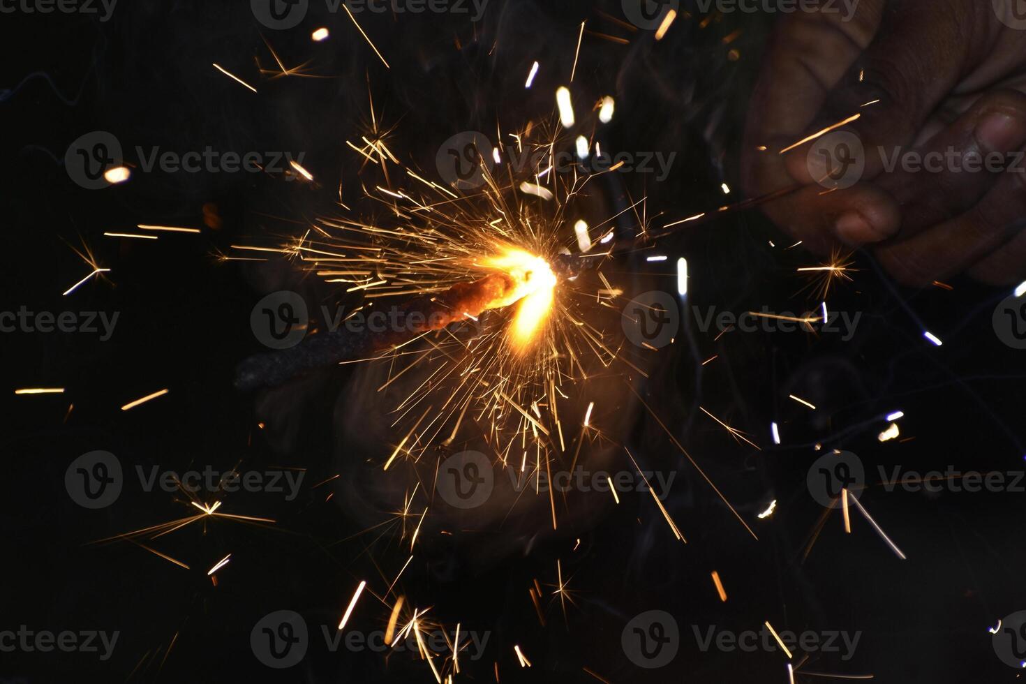 A person holding a sparkler in their hand photo