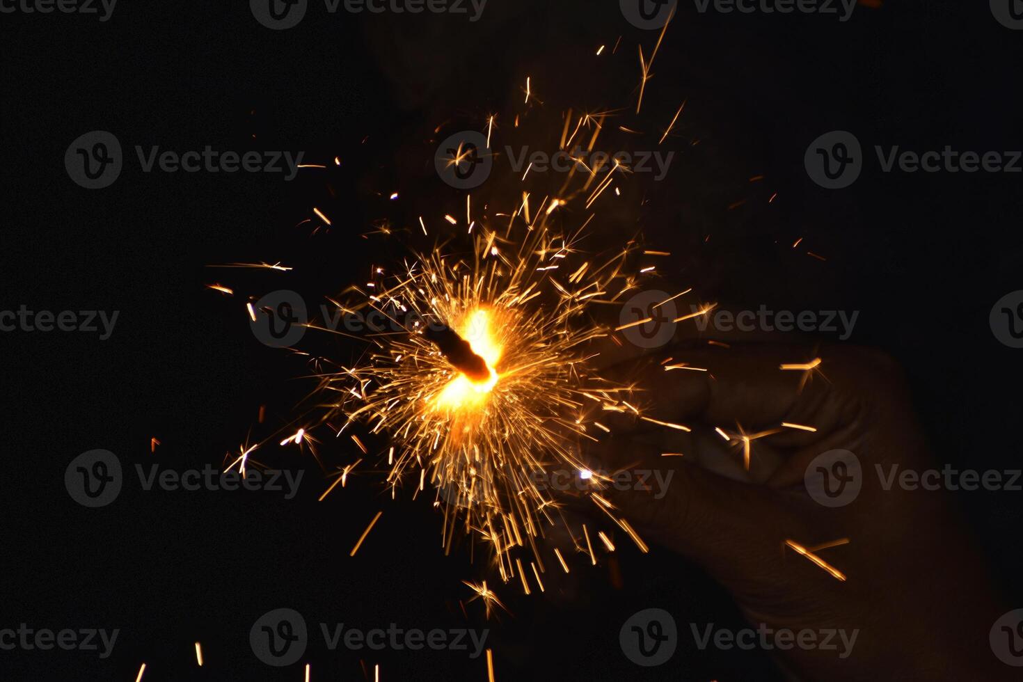 A person holding a sparkler in their hand photo