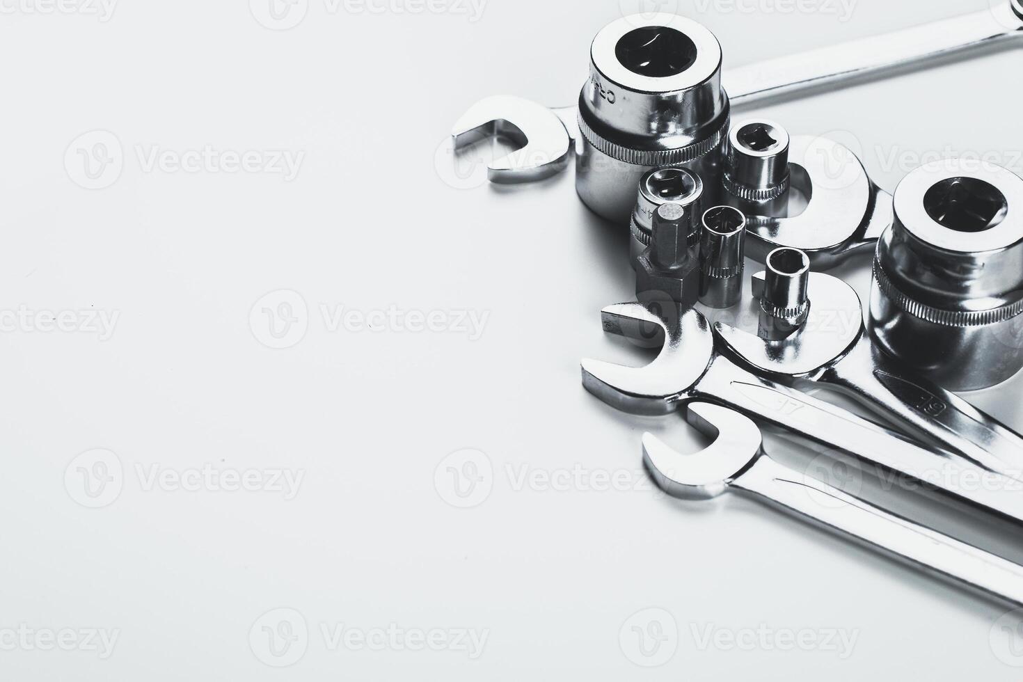 Various metallic hand tools arranged on a light surface, showcasing their functionality and design in a workshop setting photo