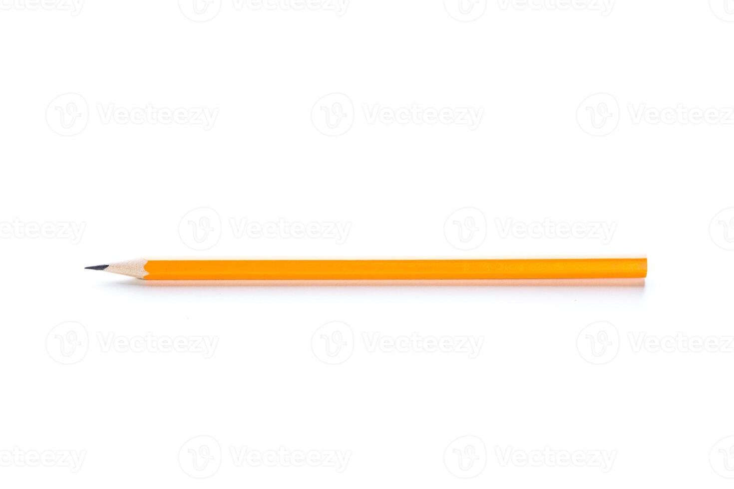Simple orange pencil lying on a flat surface with a sharpened tip ready for writing or drawing photo
