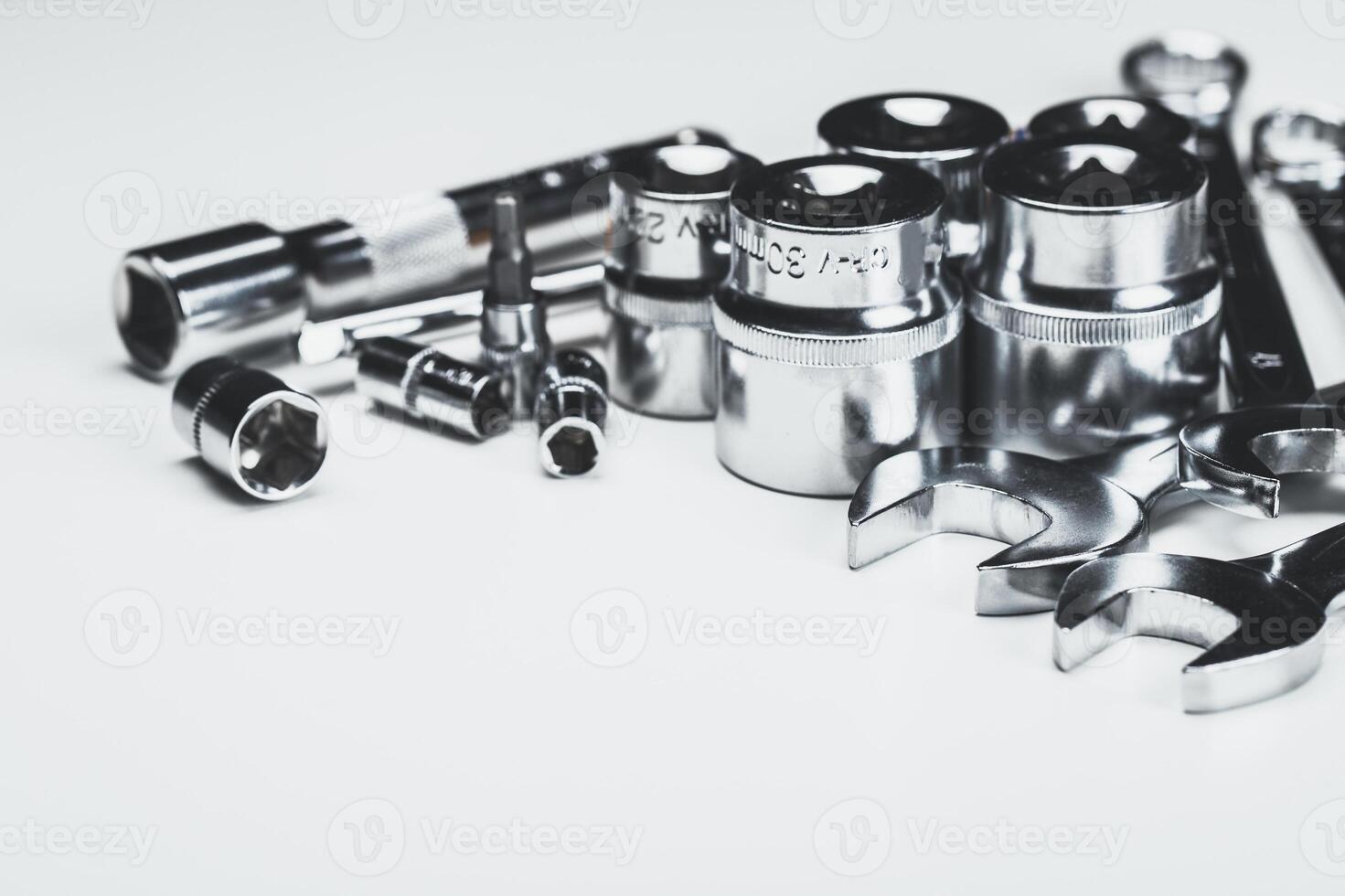 Assorted metal tools arranged on a white background for repair and maintenance tasks in a workshop setting photo