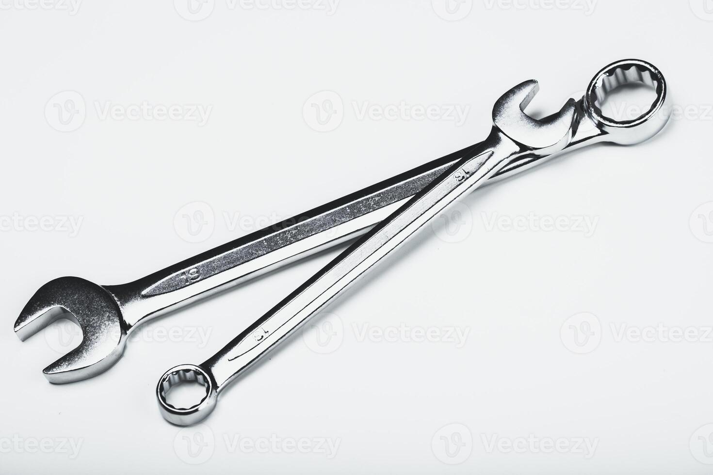 Different sizes of metallic wrenches placed on a plain surface showcasing their functionality and design photo