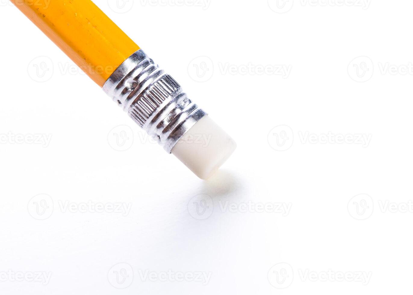 Close-up of a yellow pencil with an eraser against a clean white background illuminated by soft light photo