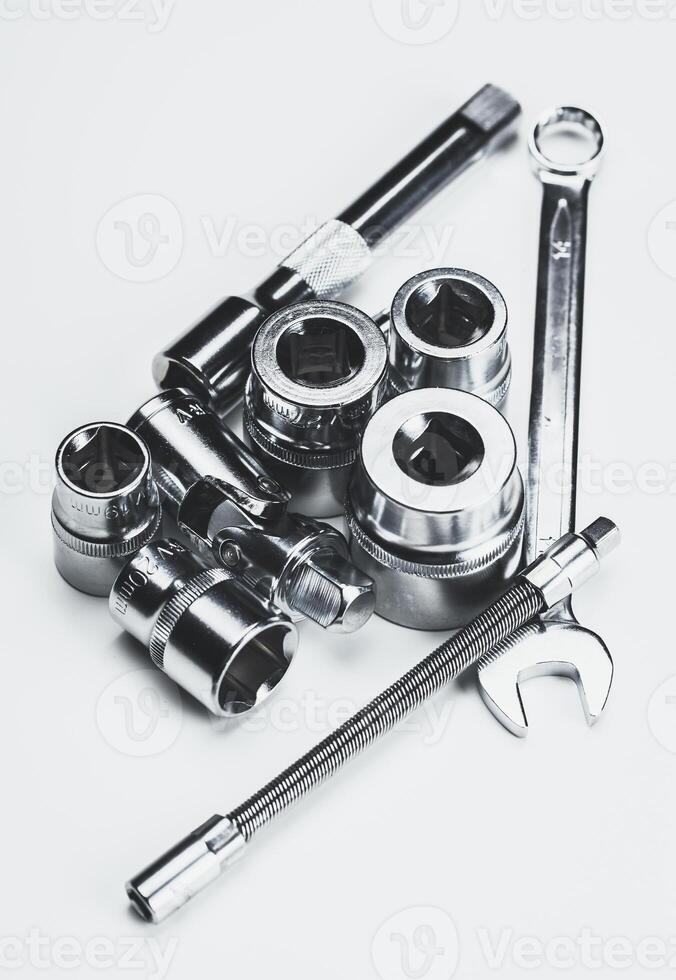 Collection of metallic hand tools arranged on a smooth surface showcasing their shine photo