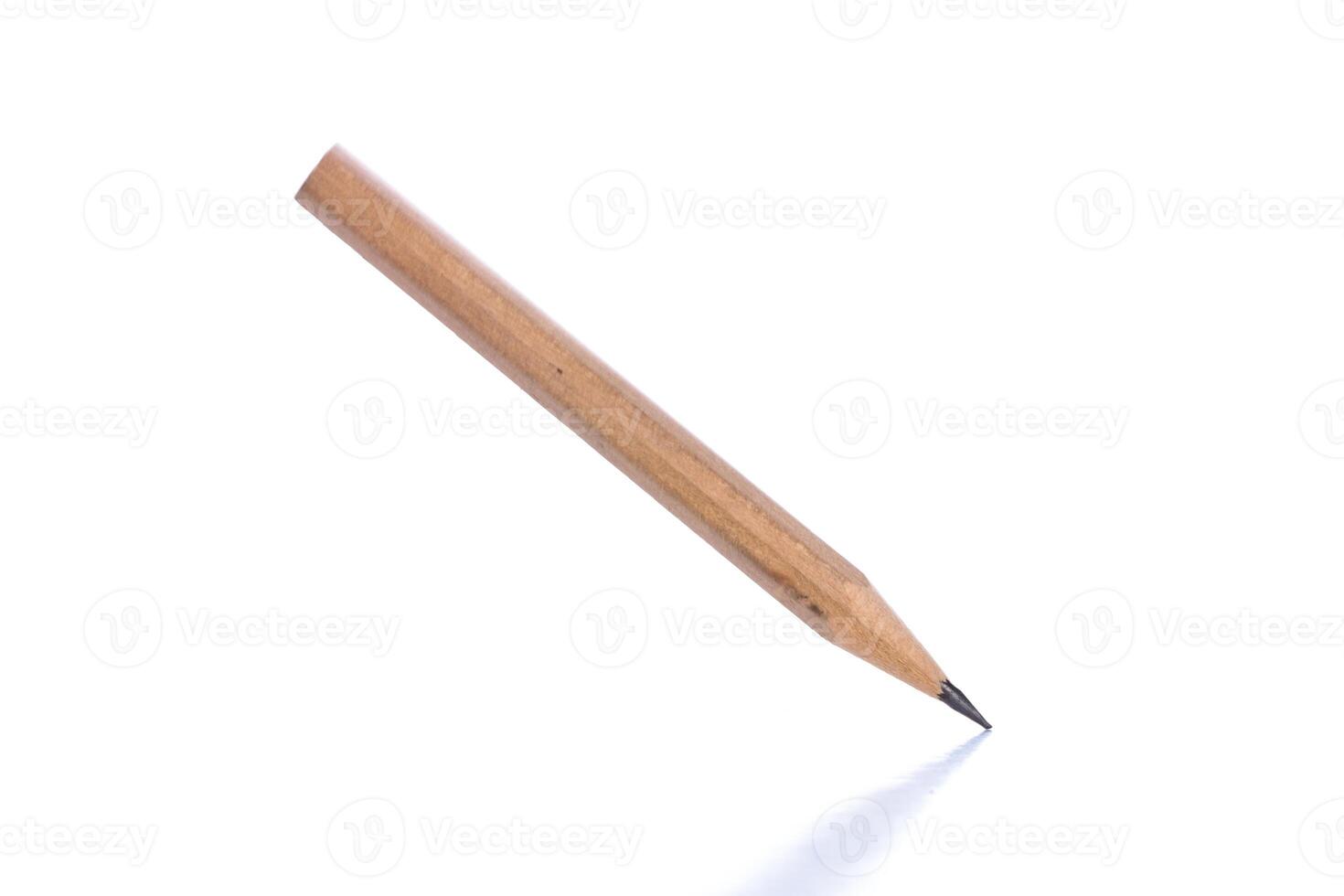 Wooden pencil placed at an angle on a white surface with a sharp point for writing and drawing activities photo