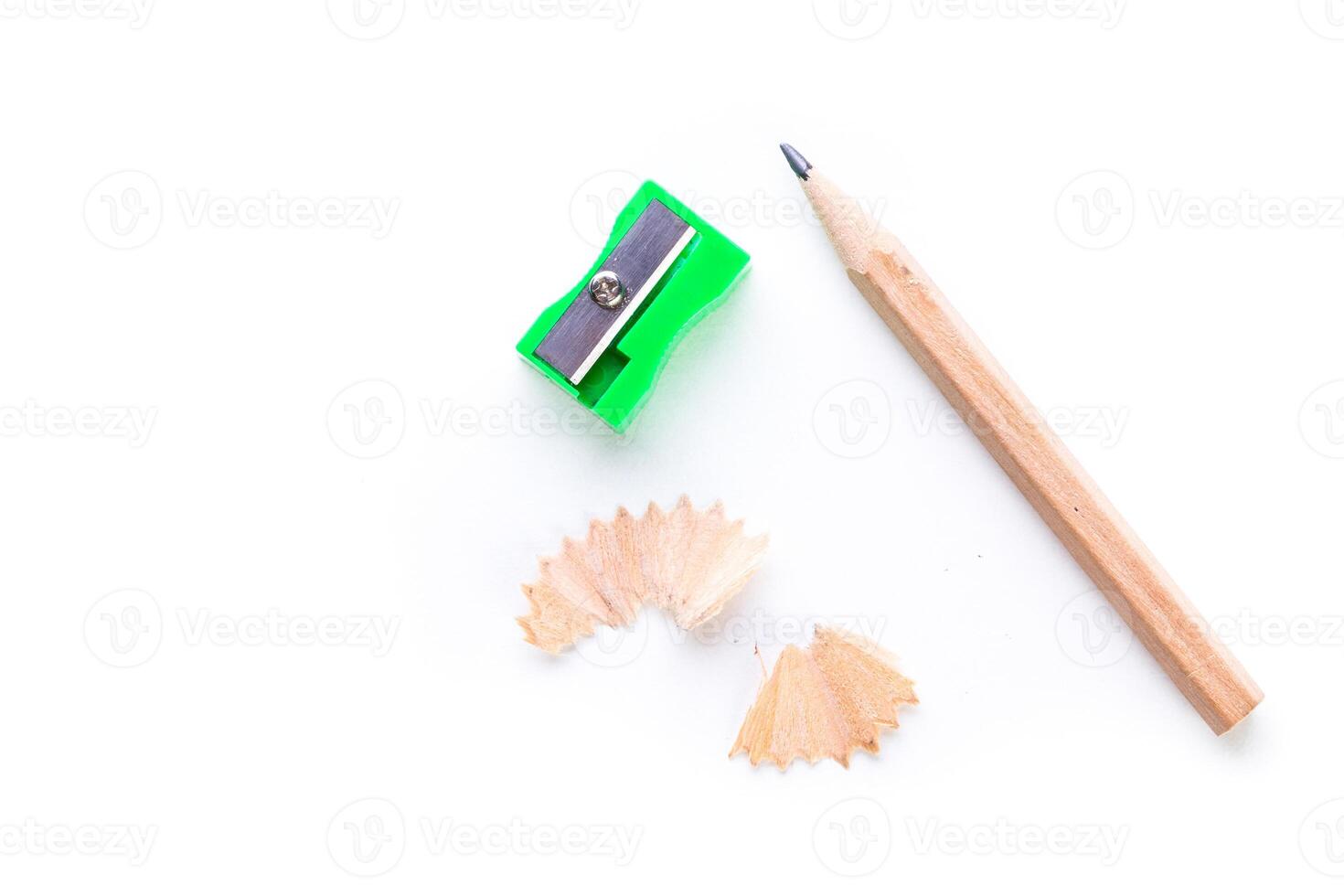Colorful pencil sharpener next to wooden pencil and shavings on a clean white background photo