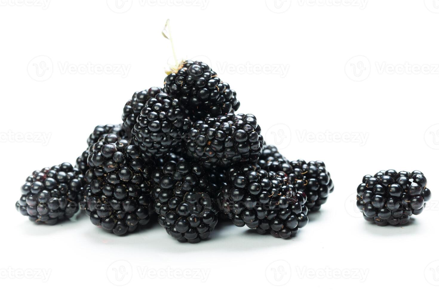 Fresh blackberries stacked and arranged on a neutral background in a close-up view showing texture and color photo