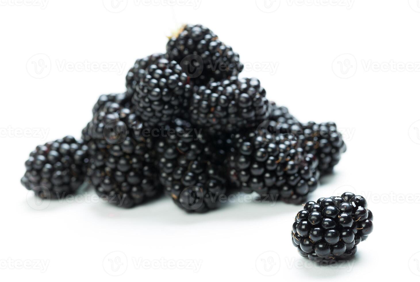 Fresh blackberries piled on a white surface, showcasing their rich color and texture, perfect for healthy snacking or culinary use photo