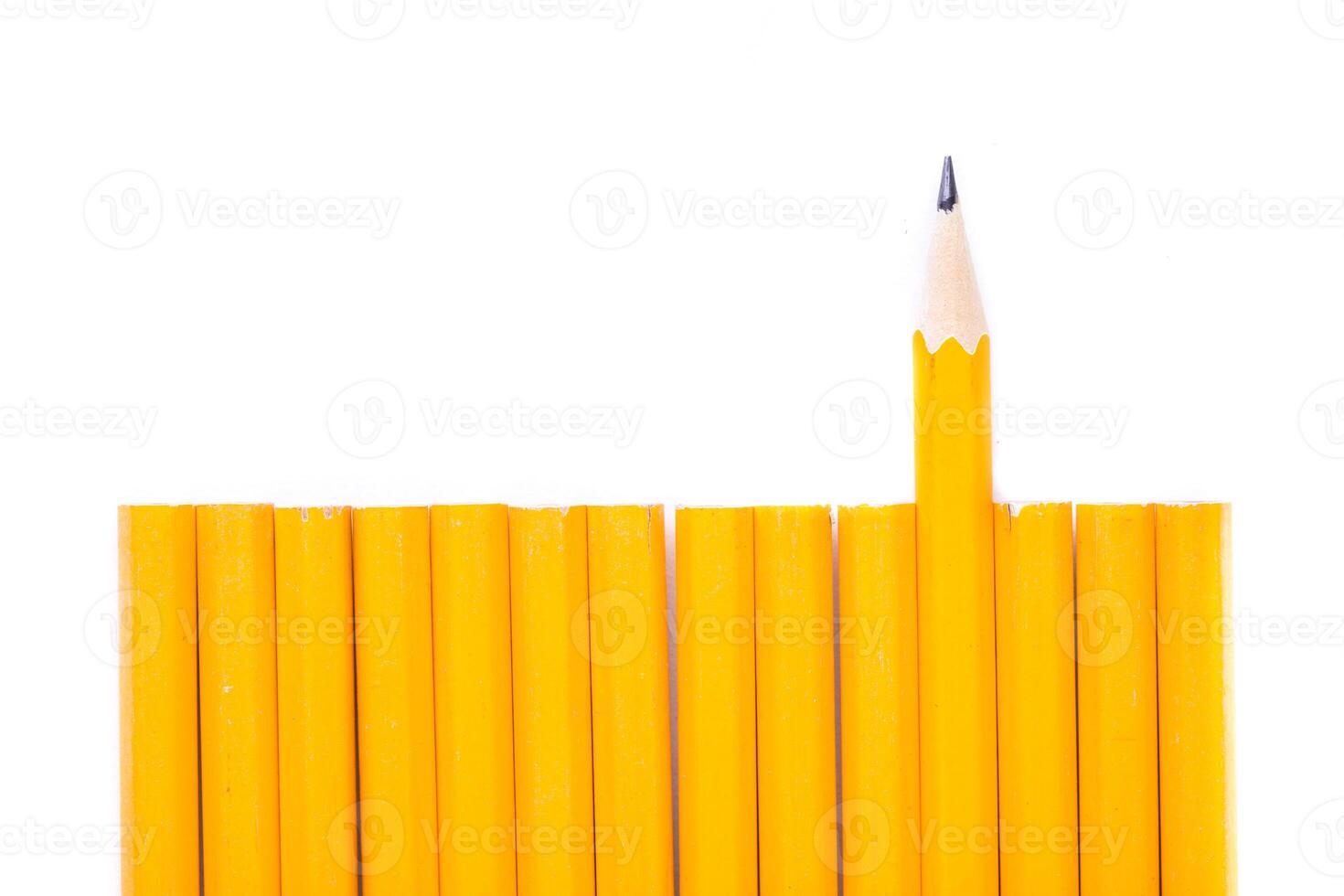 Collection of yellow pencils arranged neatly with one pencil standing out in a contrasting position photo