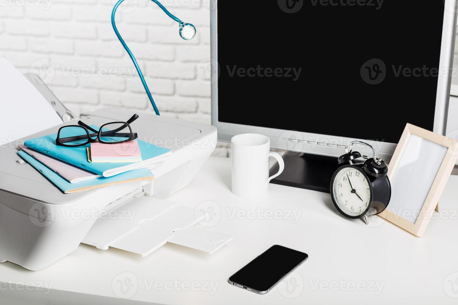 Workspace setup with printer, computer, and stationery during daylight in a modern office environment photo