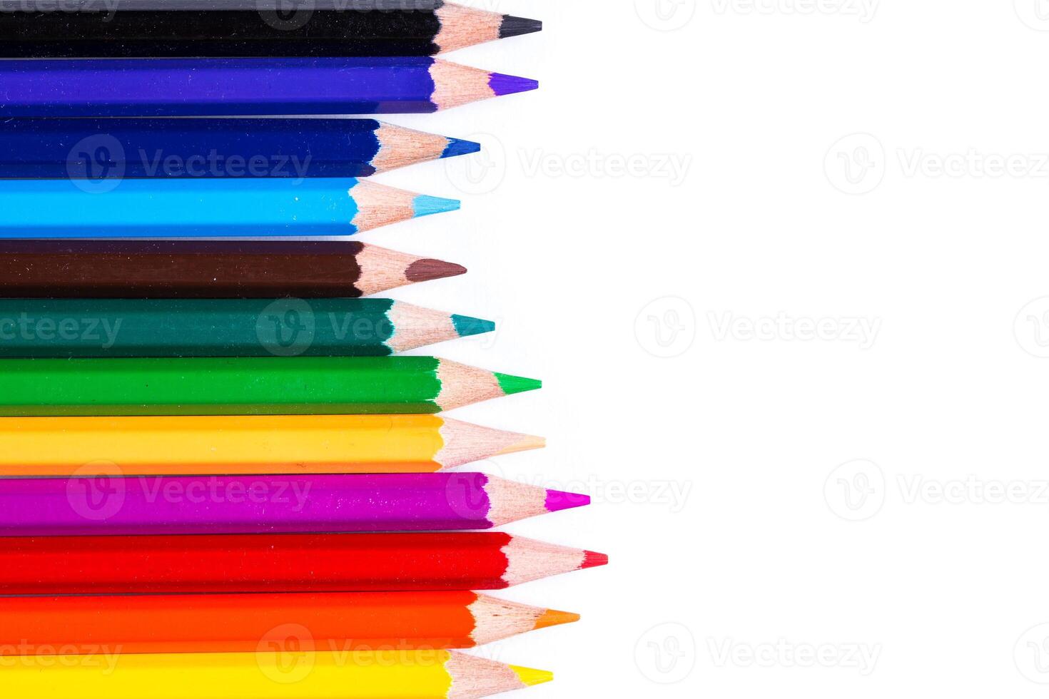 Colorful assortment of colored pencils arranged in a vibrant lineup on a clean white surface photo