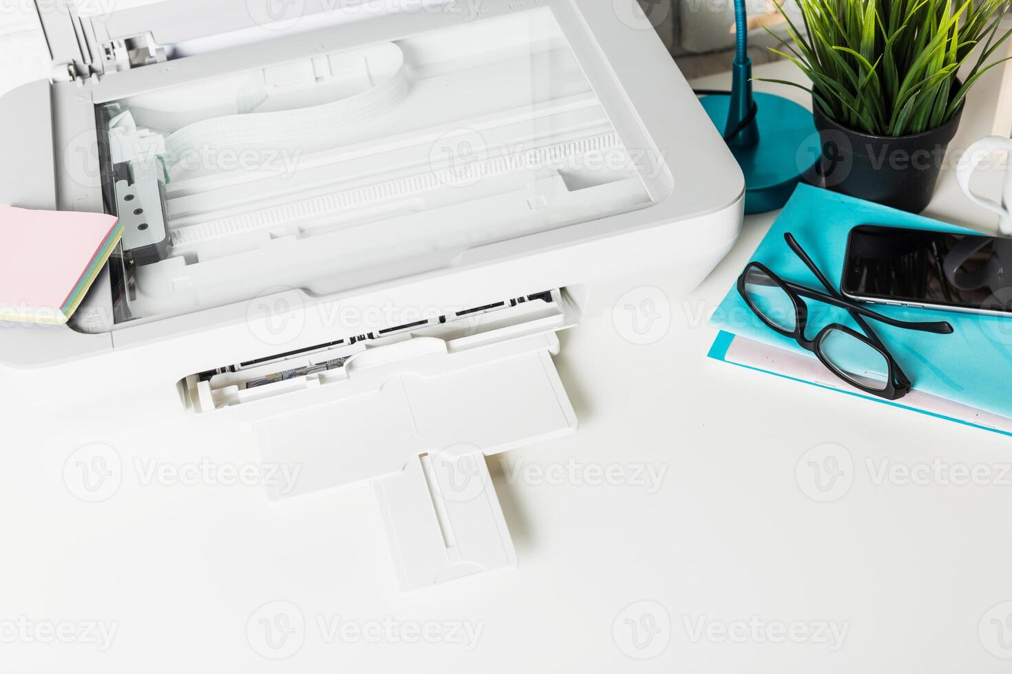 Modern workspace with printer, office supplies, and green plant in bright room for productive work environment photo