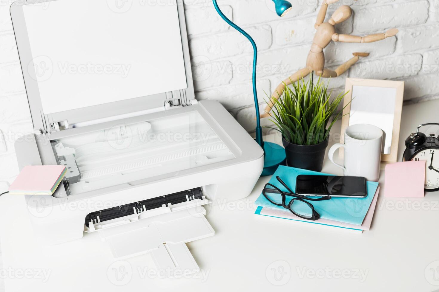 Modern workspace with printer, stationery, and plants in a bright, organized setting photo