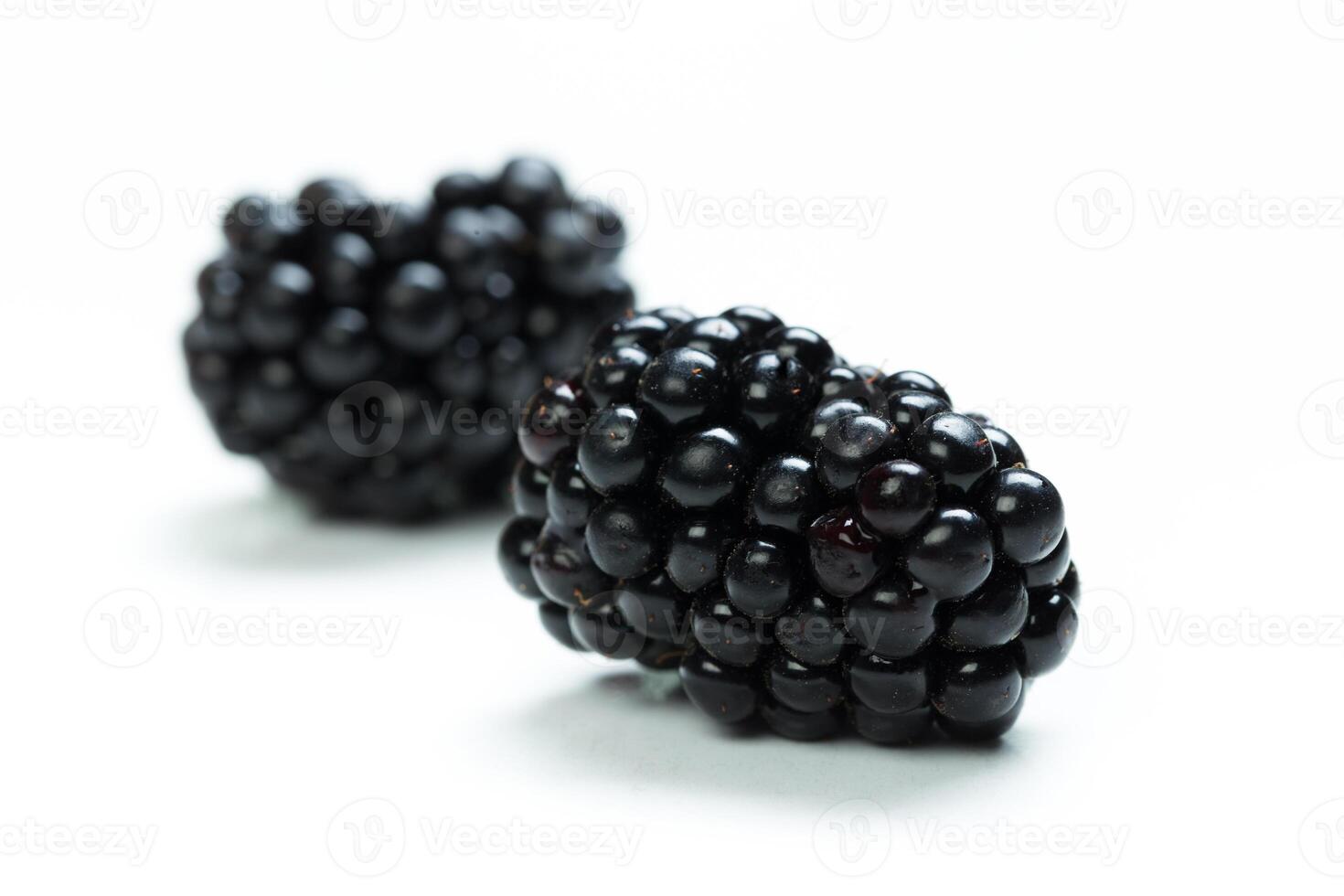 Fresh blackberries placed on a clean white surface, highlighting their rich color and texture photo