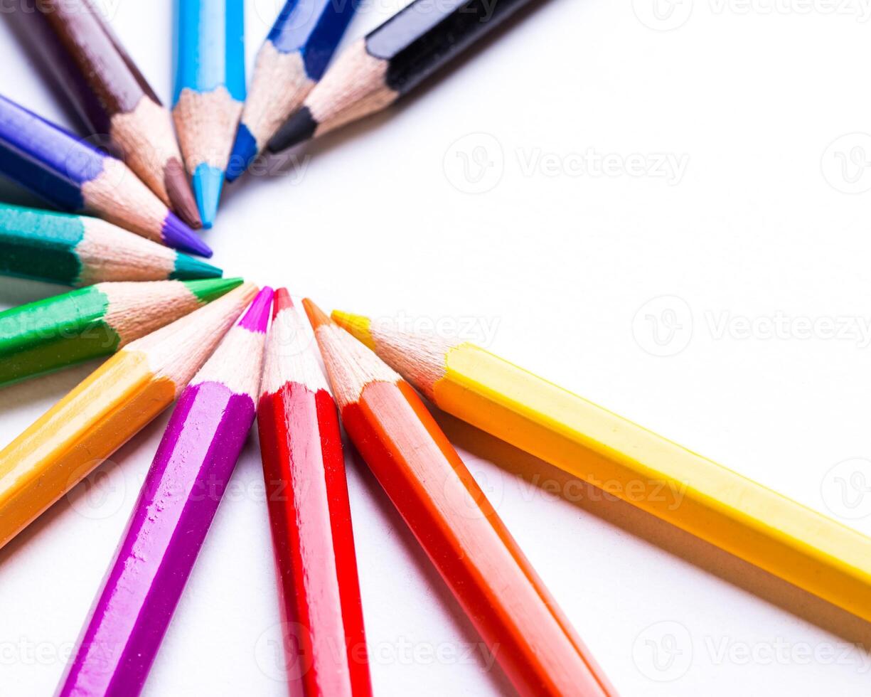 Vibrant colored pencils arranged in a circular pattern on a white surface during daylight photo
