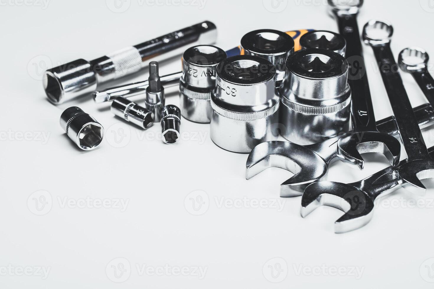 Assortment of shiny tools including sockets and wrenches on a light background for mechanic work or DIY projects photo
