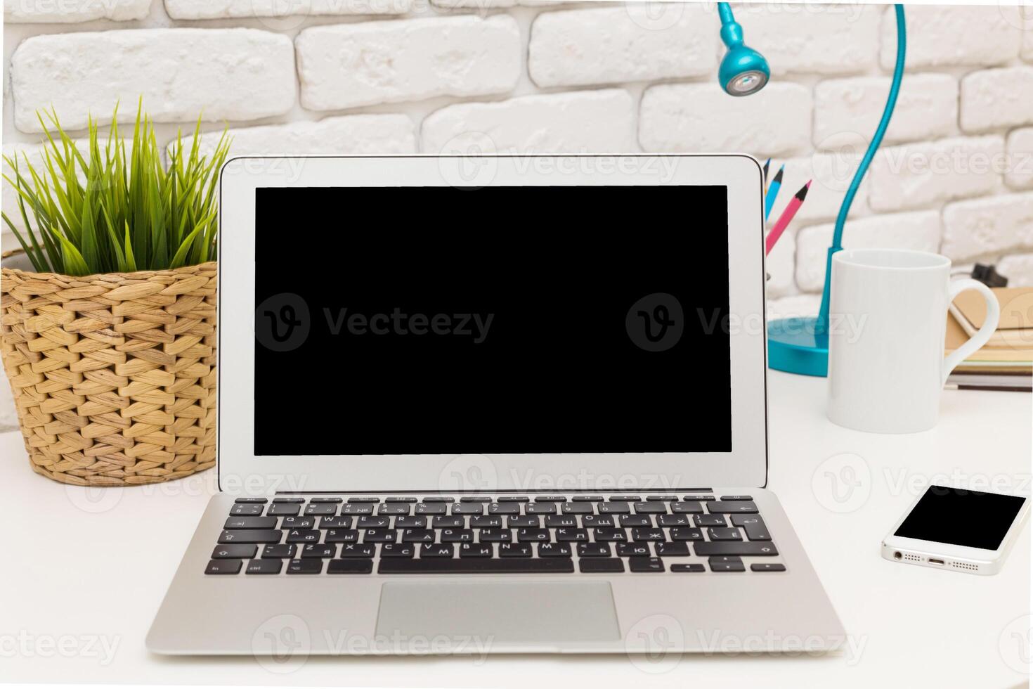 Minimalist workspace featuring a laptop, stationery, and desk lamp with vibrant colors, ideal for productivity and creativity photo
