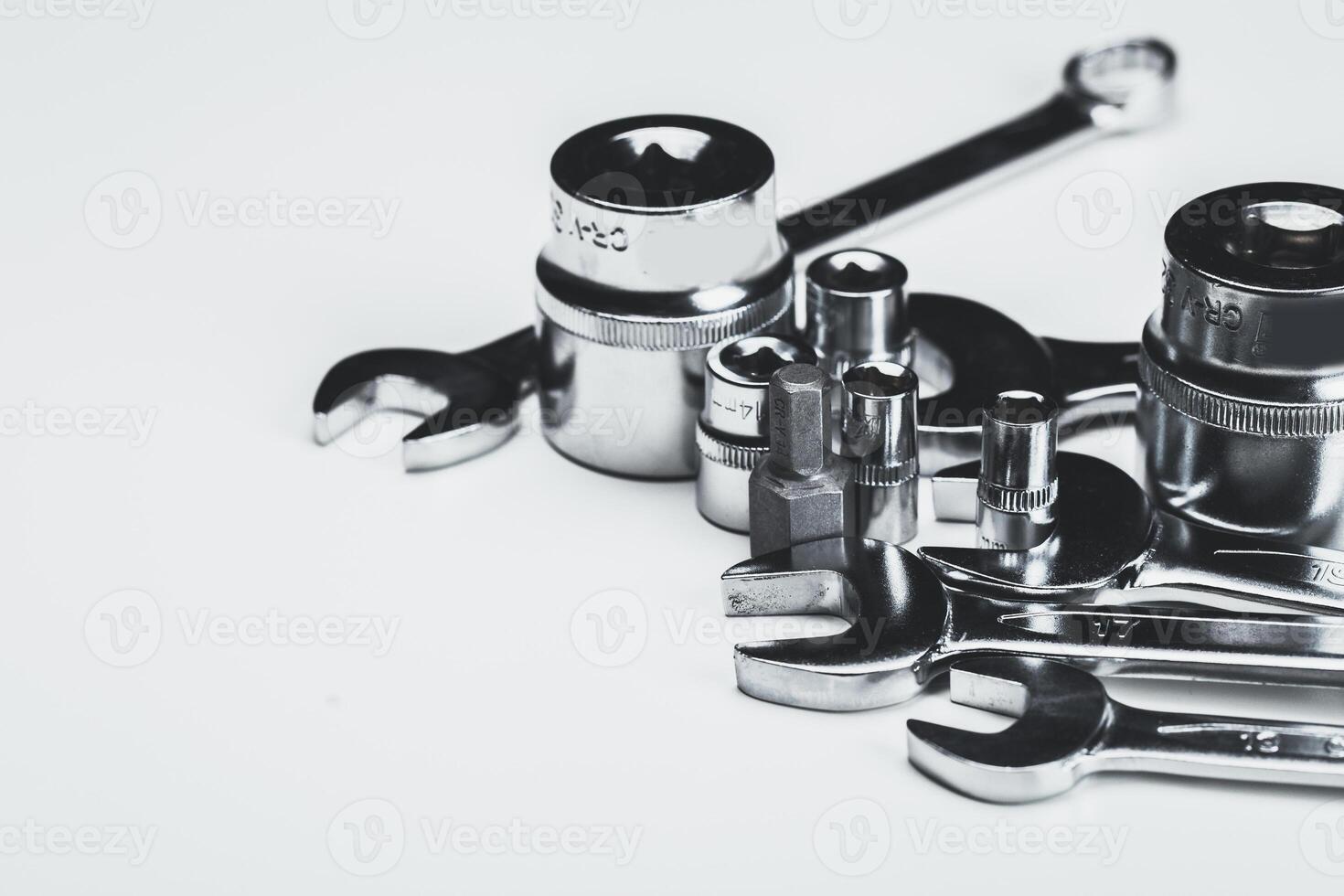 Various metal tools arranged neatly on a light surface in a workshop setting for repair tasks photo