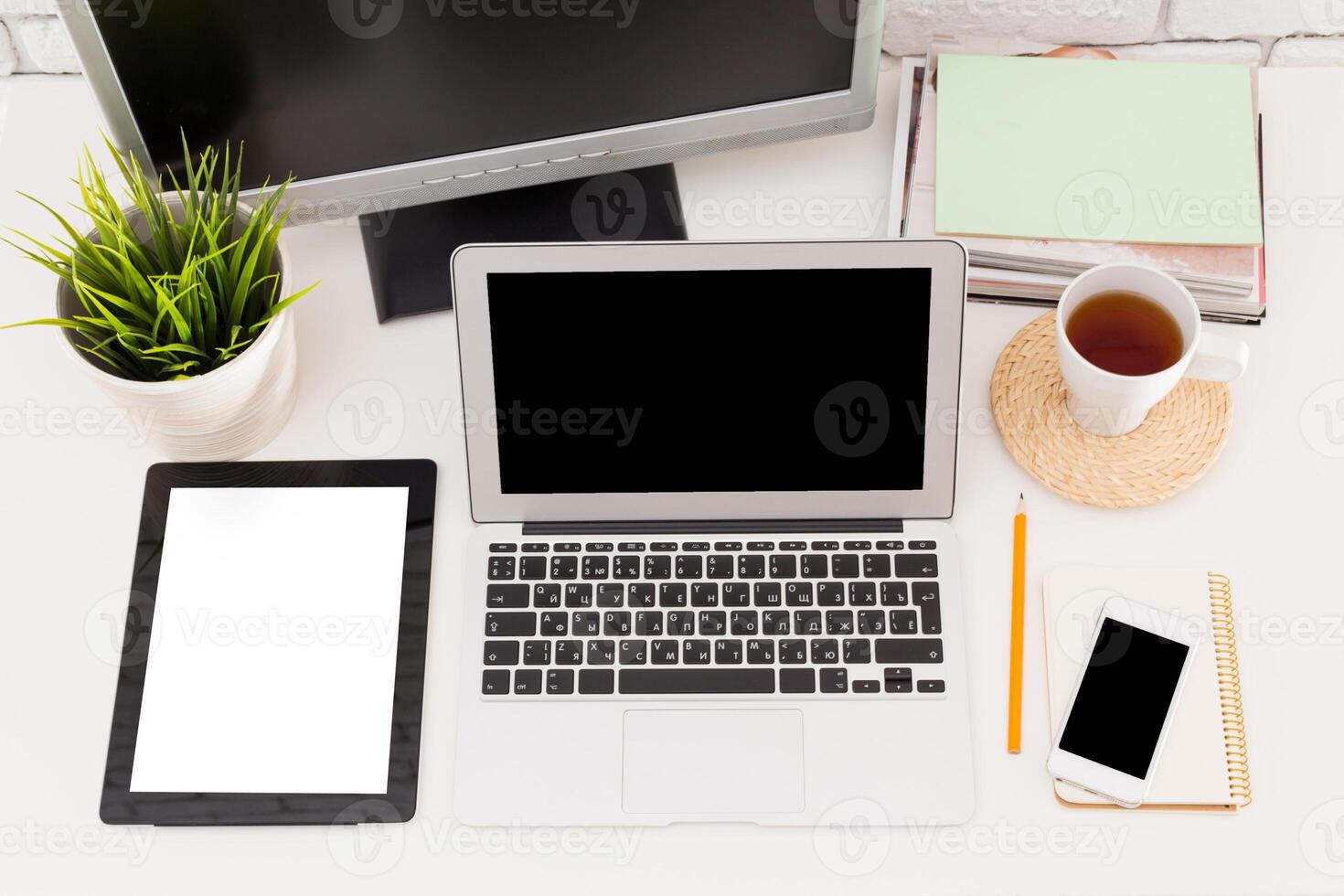 Modern workspace setup with laptop, tablet, and cozy decorative elements photo