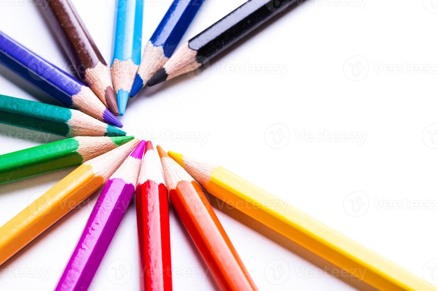 Colorful pencils arranged in a circular pattern on a white background photo