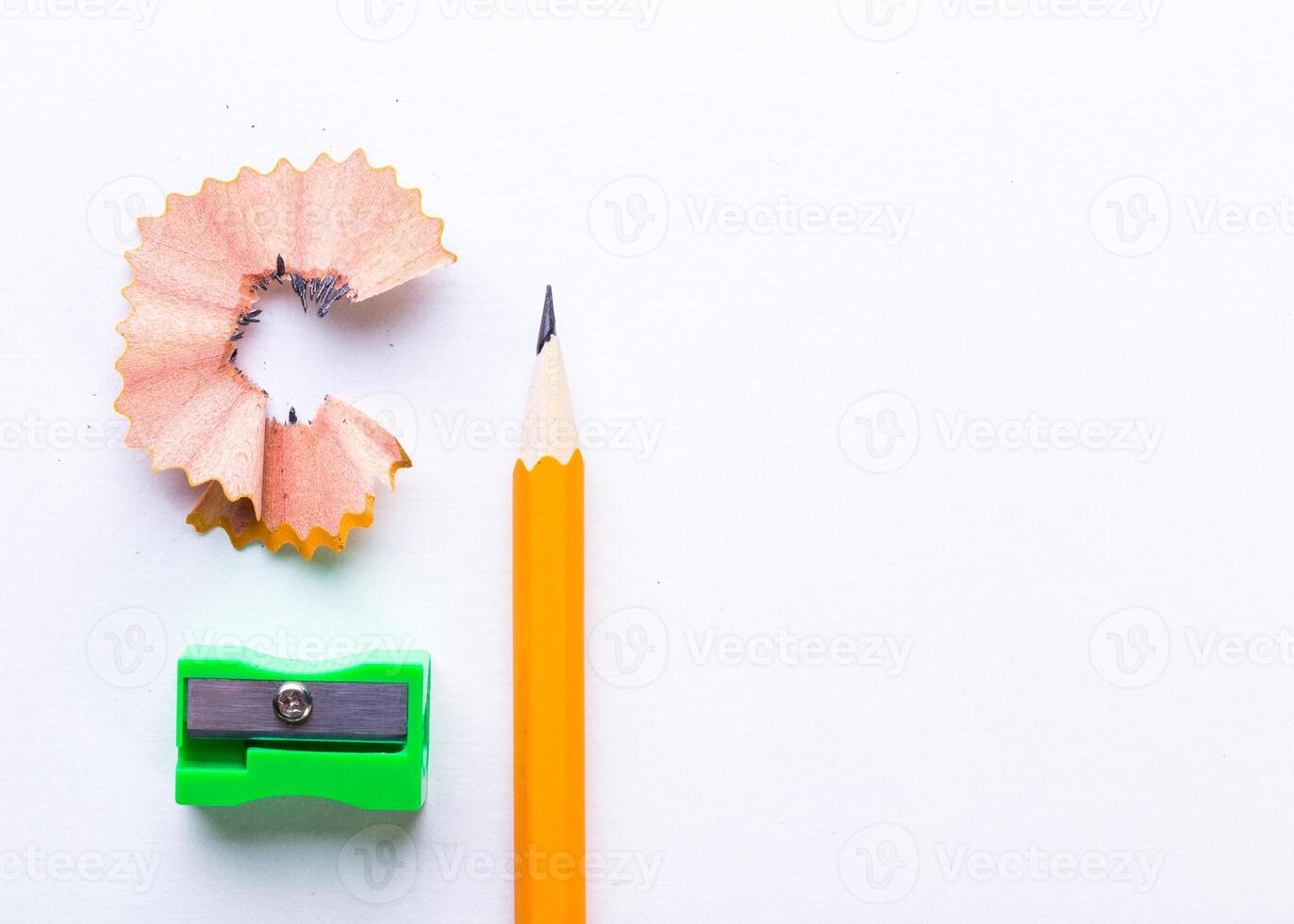 Colorful pencil, sharpener, and shavings arranged on a clean white surface highlighting office supplies and school essentials photo