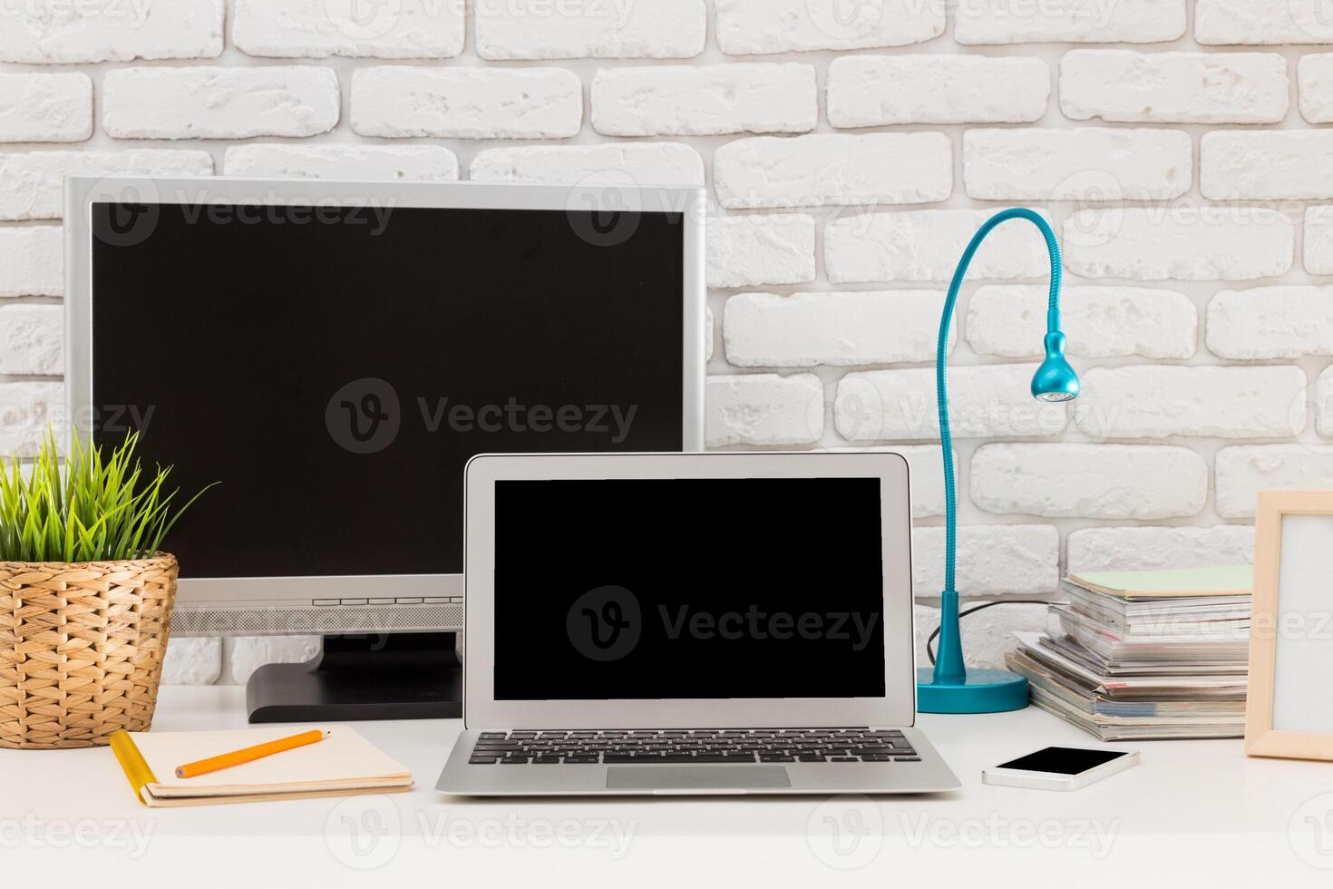 Modern home office setup featuring a laptop, monitor, and organized workspace during daytime photo