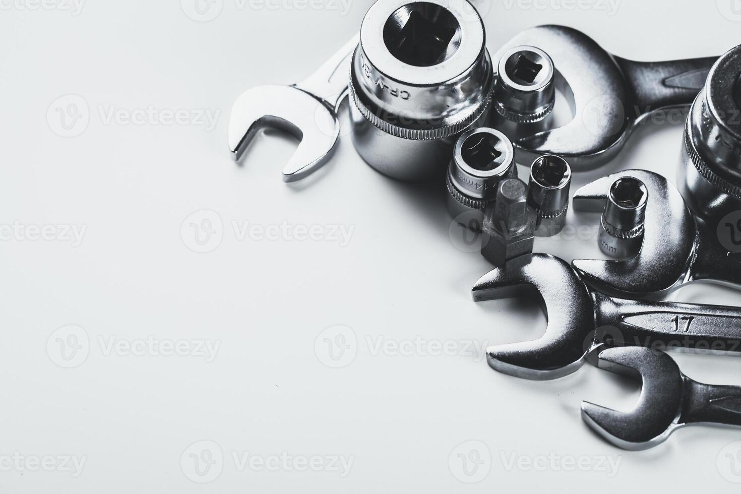 Collection of various metallic tools arranged on a plain surface showcasing their distinct shapes and sizes photo