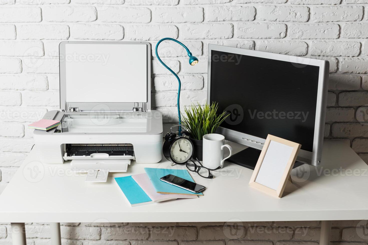 Modern workspace setup with printer, monitor, and office supplies in a cozy environment photo