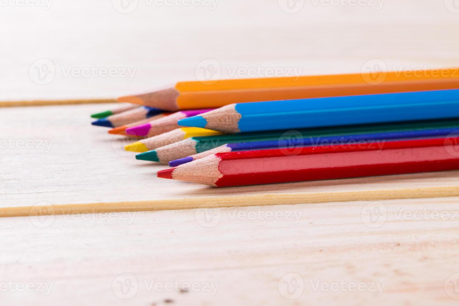 Colorful pencils arranged neatly on a wooden surface for creative projects and artistic expression photo