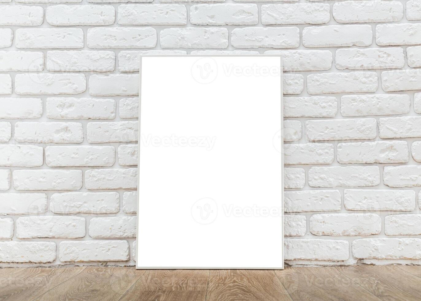 Blank white canvas positioned against a textured white brick wall in a simple interior setting photo