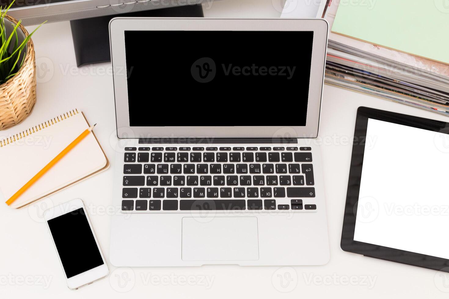 Work station overview with laptop, tablet, smartphone, and stationery on a clean desk photo