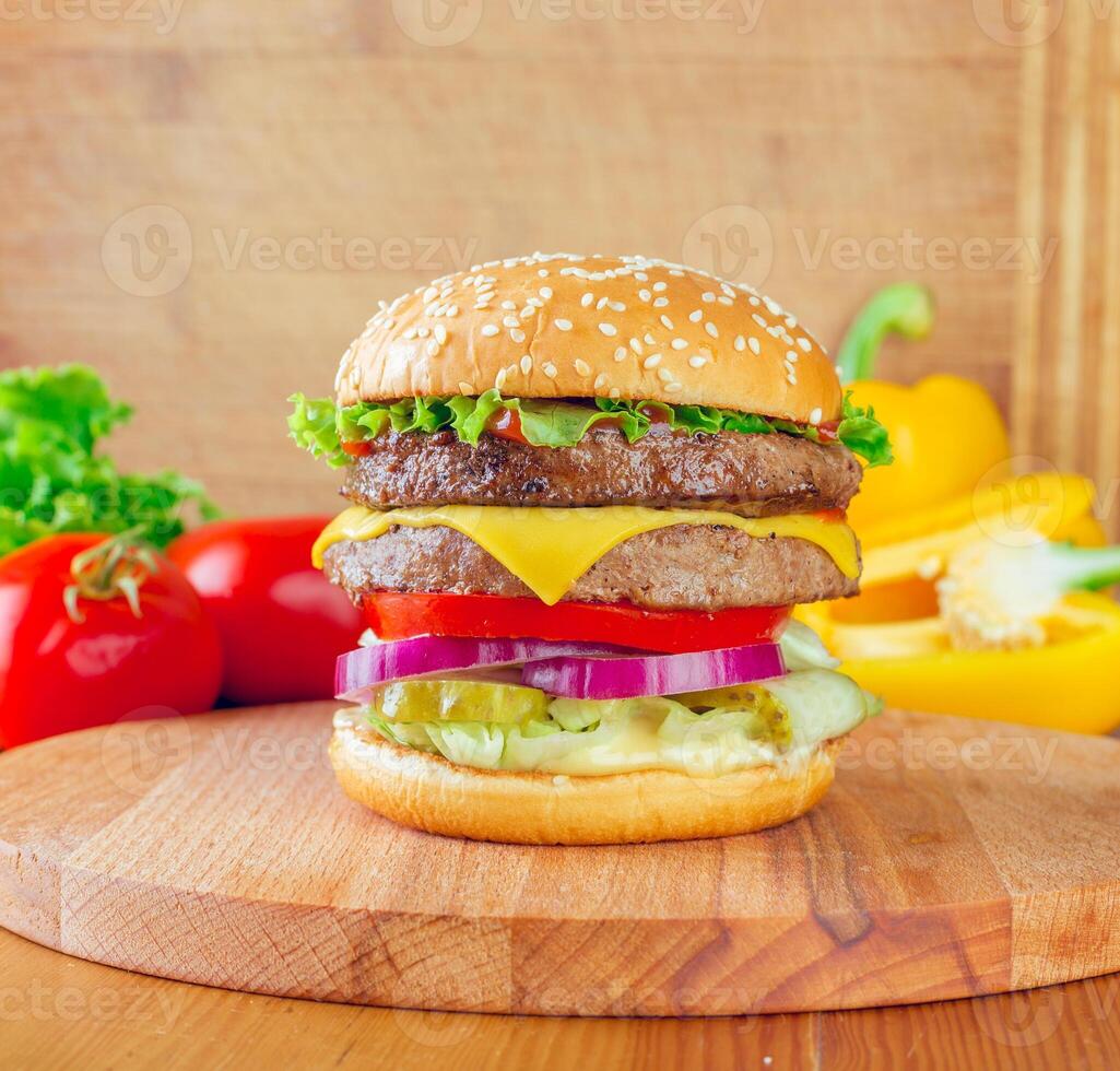 Delicious double cheeseburger on a wooden cutting board with fresh vegetables at a casual dining setting photo