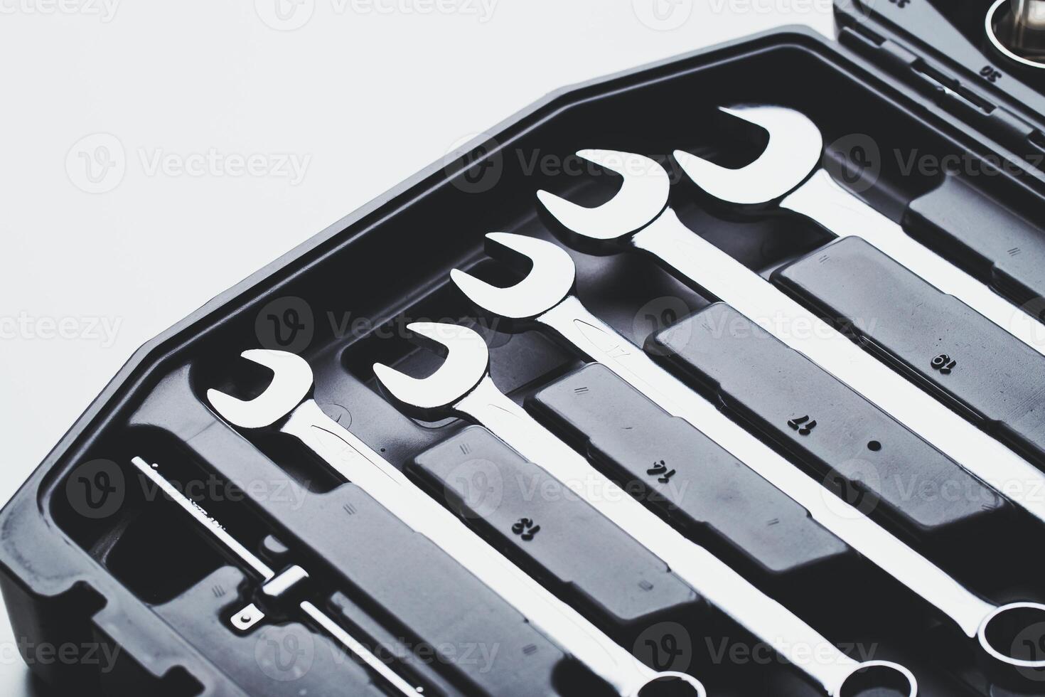 Detailed view of a wrench set organized inside a black tool case on a clean surface photo