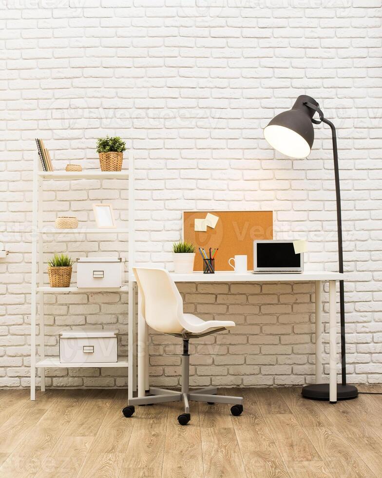 Modern workspace featuring a clean desk, shelving, and warm lighting in a minimalist setting photo