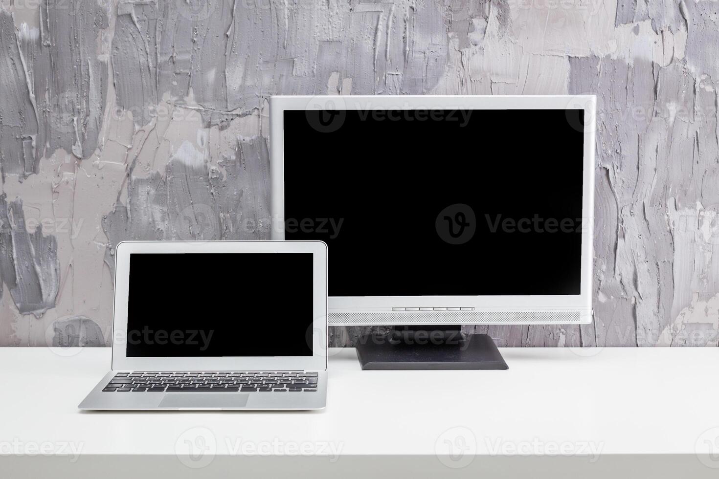 Modern workspace featuring a laptop and a computer monitor on a minimalist desk during daylight photo