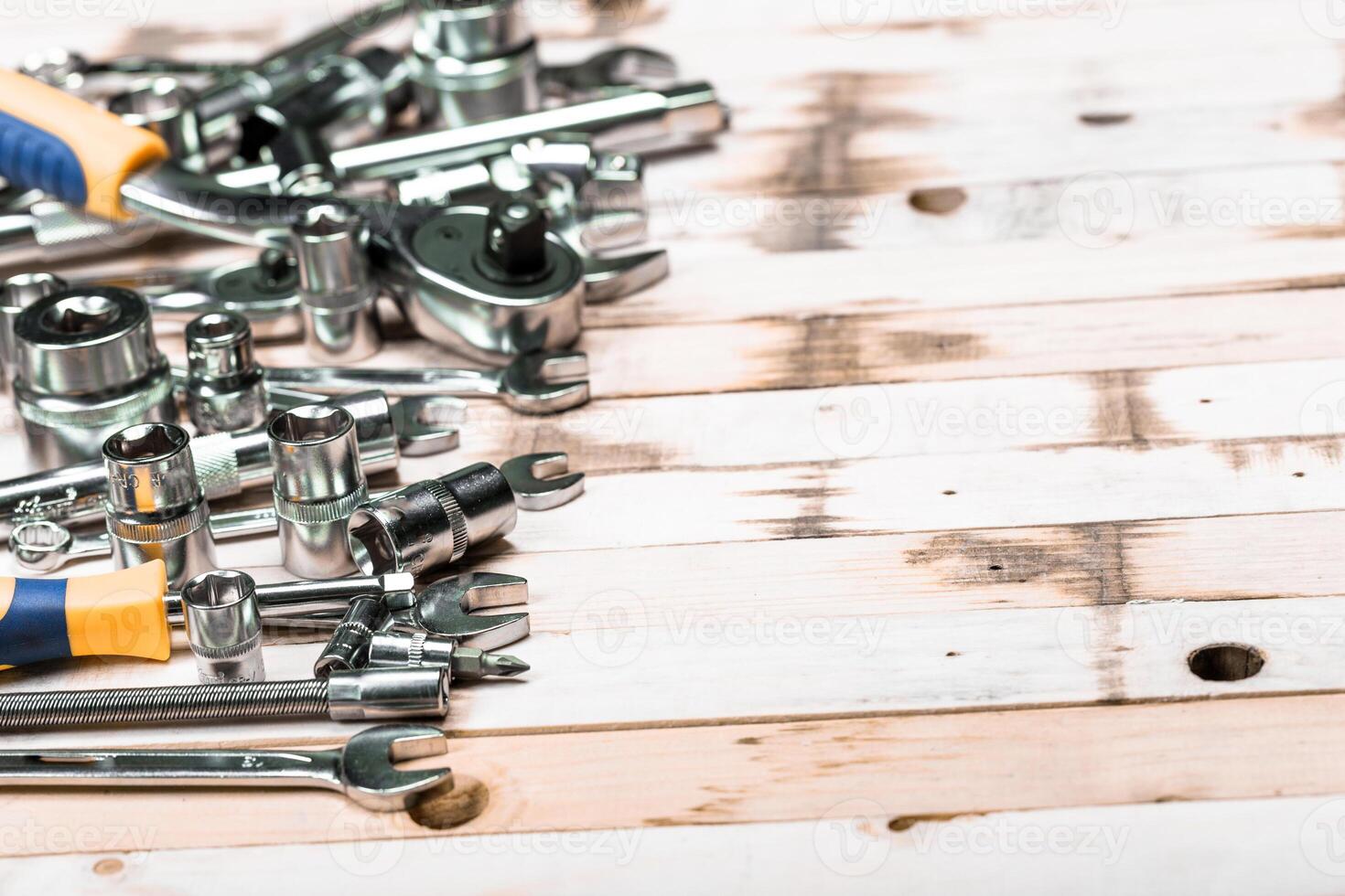 Collection of various hand tools displayed on a rustic wooden surface in a workshop setting, showcasing craftsmanship and utility photo